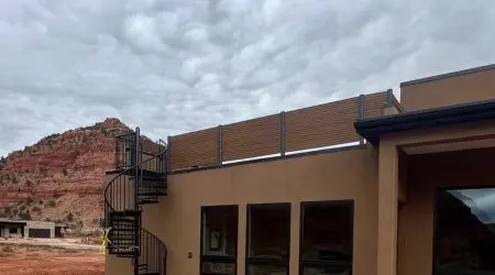 Rooftop deck with composite privacy screen and spiral staircase by Diamond Decks