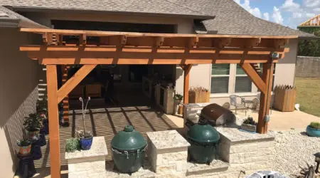 Cedar pergola on stucco home shading Big Green Egg kitchen by Diamond Decks, San Antonio TX