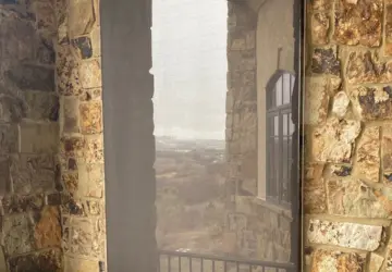Retractable screen shade enclosing a stone patio doorway