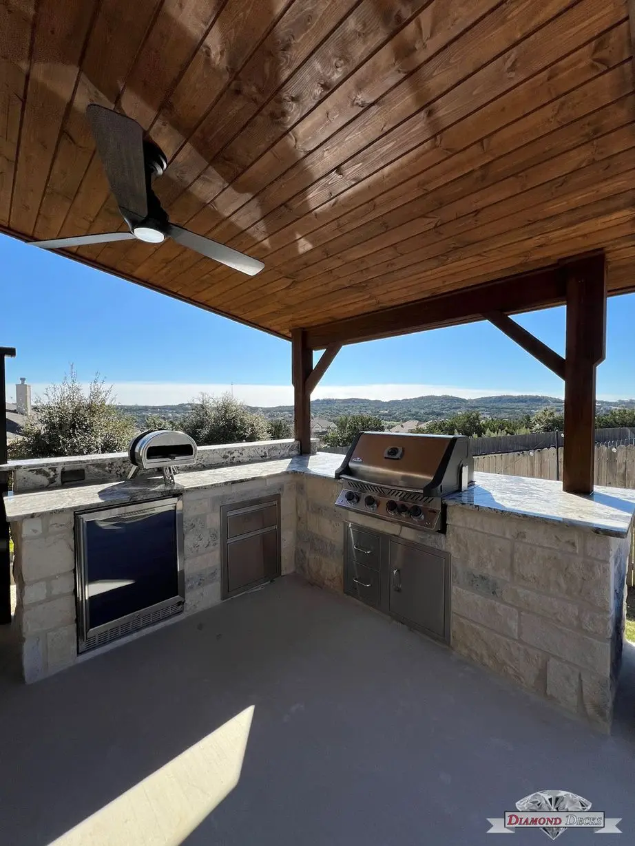 Limestone outdoor kitchen with pizza oven and grill by Diamond Decks in San Antonio, TX