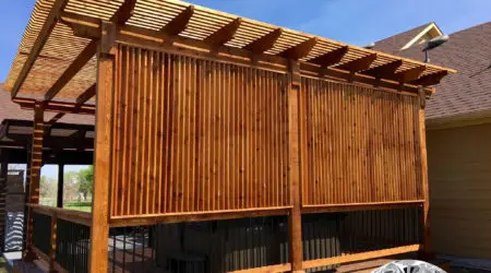 Cedar pergola with tall slat privacy screens on a deck by Diamond Decks, San Antonio TX