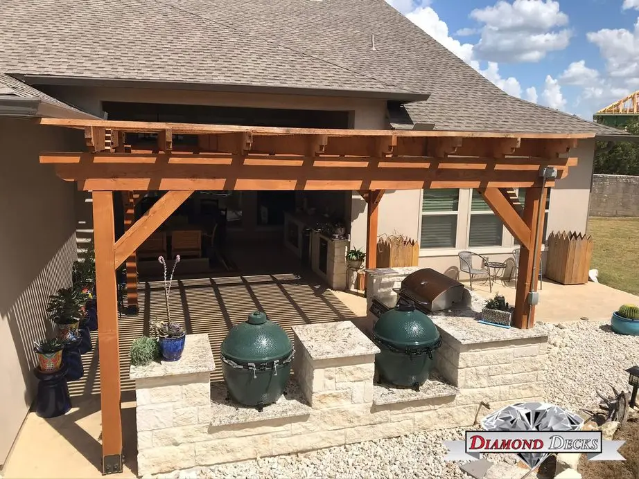 Cedar pergola on stucco home shading Big Green Egg kitchen by Diamond Decks, San Antonio TX