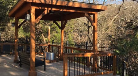 Cedar gazebo with solid roof, lantern posts and iron railing by Diamond Decks, San Antonio TX