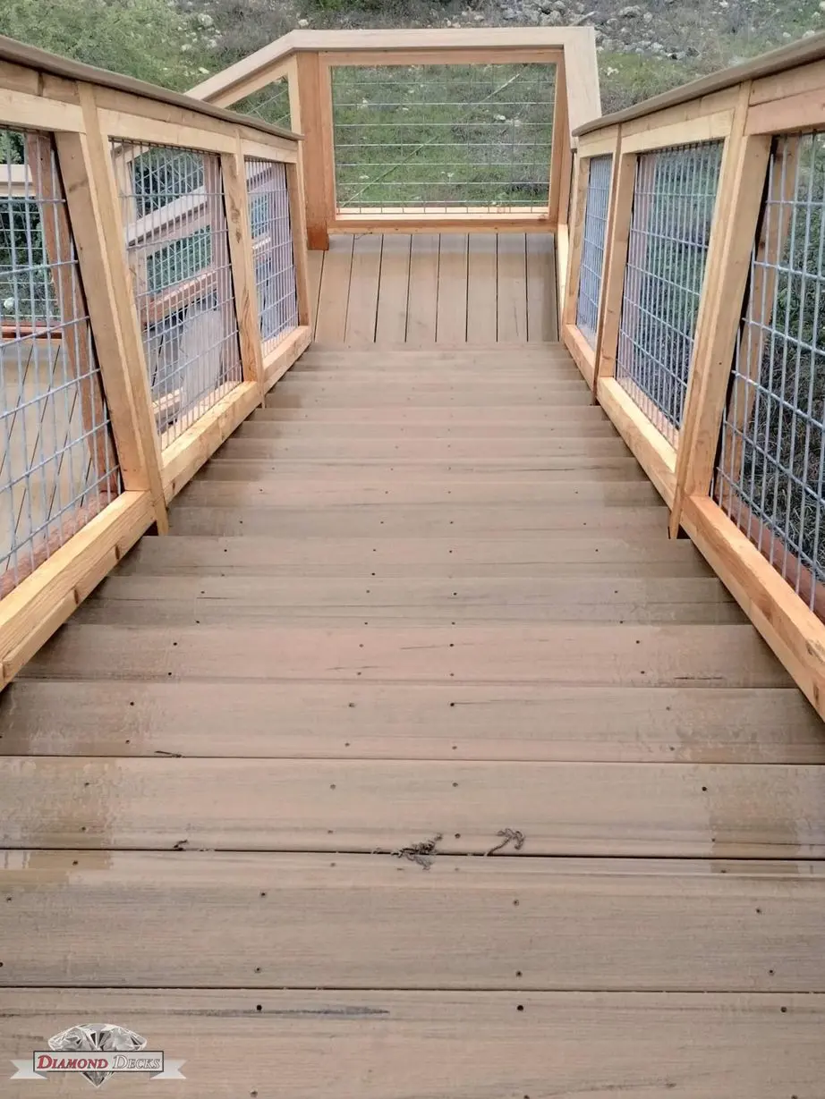 Wood staircase with cedar-framed wire mesh deck railing by Diamond Decks