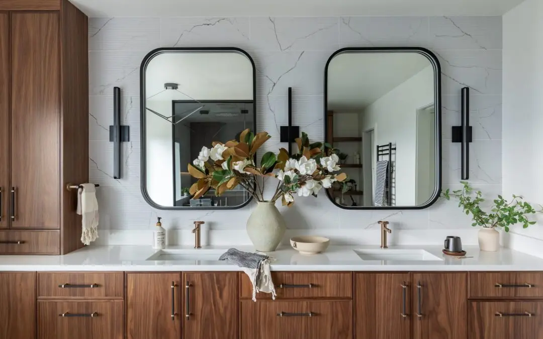 Walnut double vanity with black framed mirrors and brass faucets in a bathroom remodel in Renton, WA