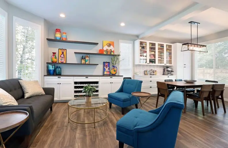 Open concept living and dining addition with white built-ins and blue chairs Open concept living and dining addition with white built-ins and blue chairs