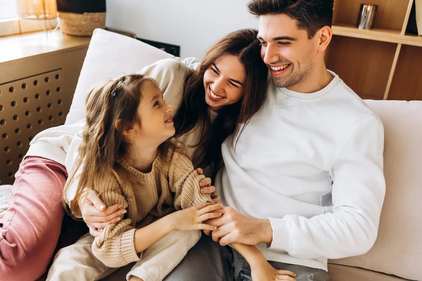 Happy family sharing a tender moment on the sofa, embracing and smiling together