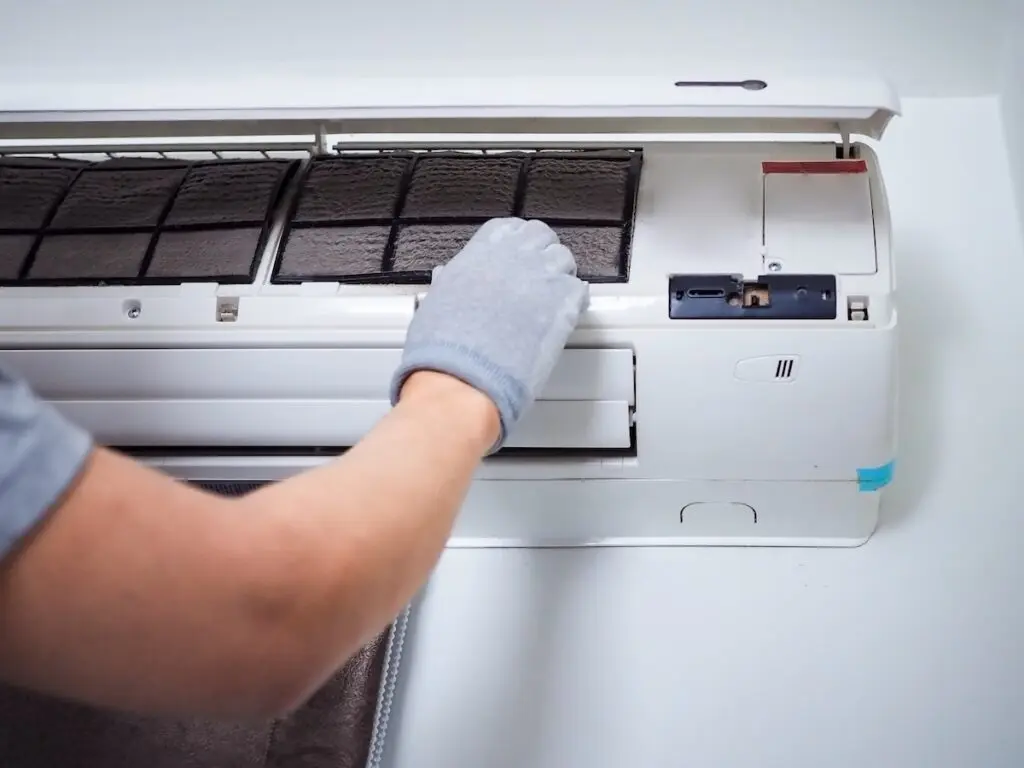 Men cleaning the filter of air conditioner interior of the house