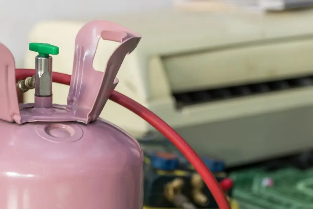 a pink ac refrigerant with a green hose