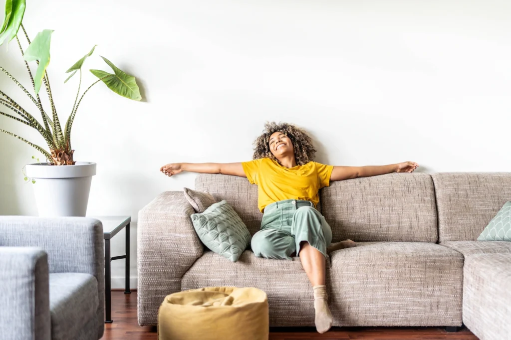 happy homeowner enjoys time relaxing on the couch in good smelling home