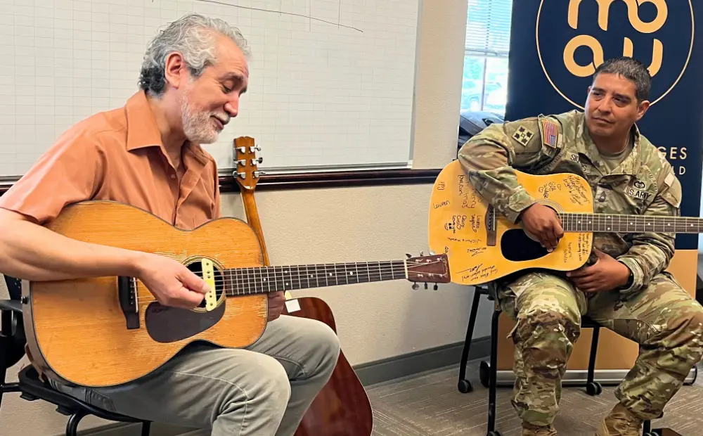 Happy playing guitar with a military musician