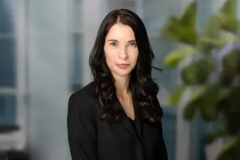 A woman with black hair wearing a black button up shirt looks directly into the camera with a soft smile. This is Anne Warden the new CEO of the APC and APPB.