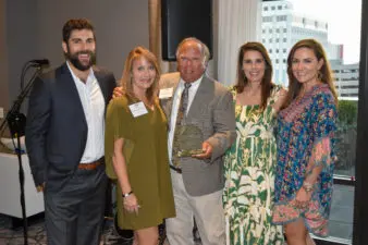 A family of five stand together at award ceremony.