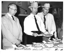 Three men look at and judge inshell pecan entries in one of the first Texas Pecan Show