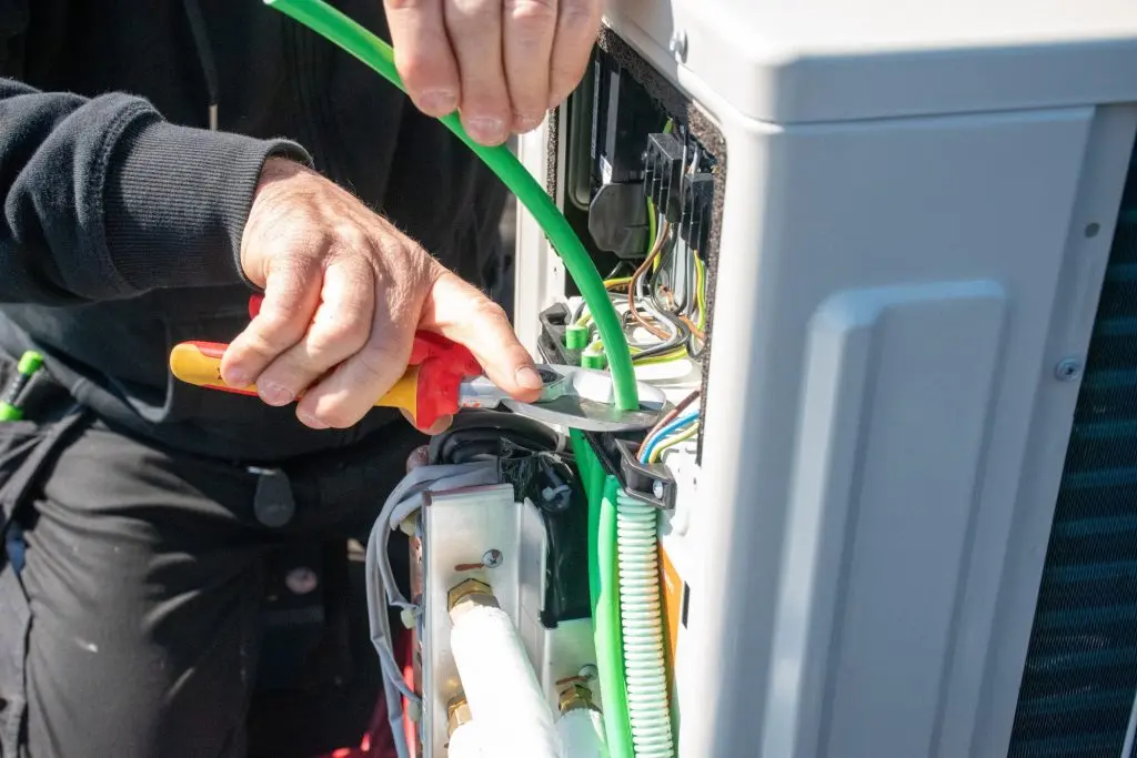 Technician Installing Modern Outdoor Air Conditioning Unit