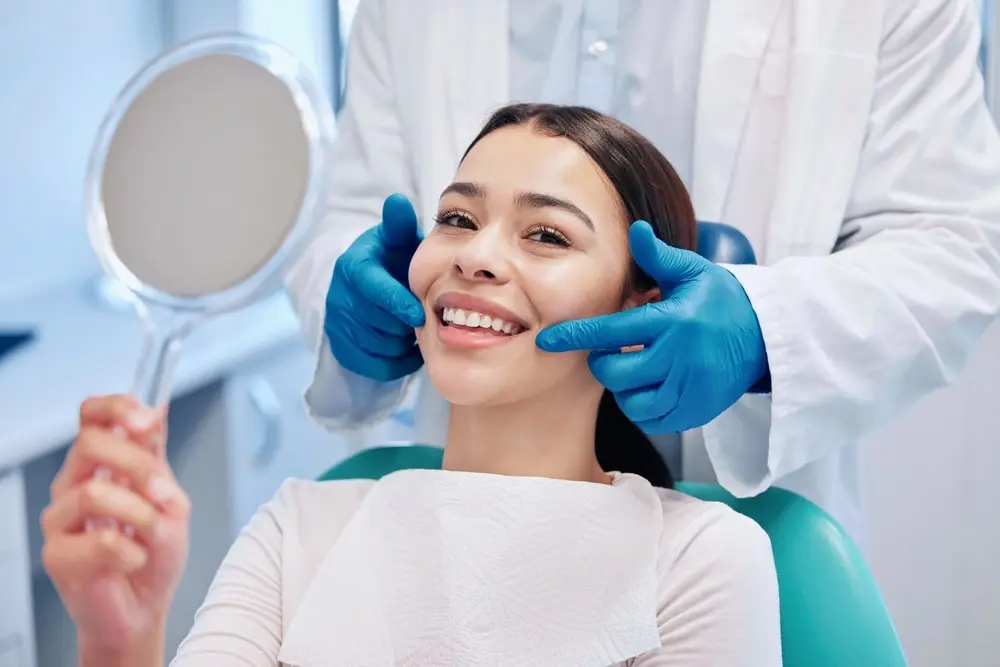 Woman smiling at the dentist showing her teeth after receiving dental sealants