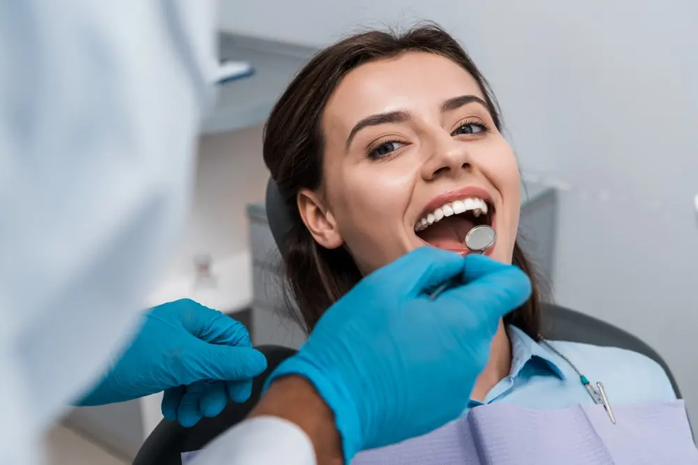 Woman is being examined at the dentist as part of a general dentistry service