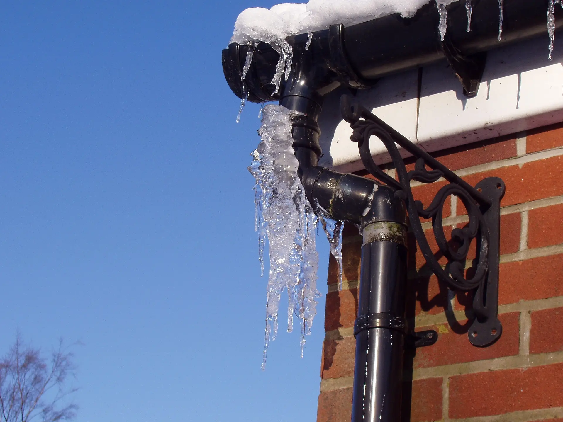Icicles hanging from a snow-covered roof edge and gutter