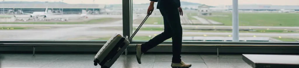 side view of businessman with business suit walking in airport terminal before boarding