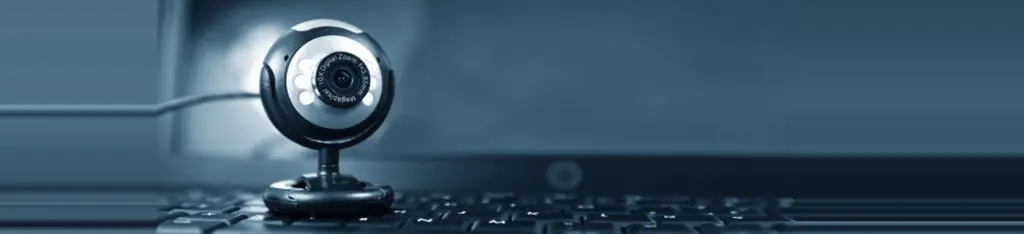 Close-up of a webcam positioned on a laptop keyboard.