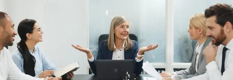 Lawyers discussing documents around a conference table in an office Lawyers discussing documents around a conference table in an office