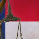 Justice statue in front of a United States of America flag