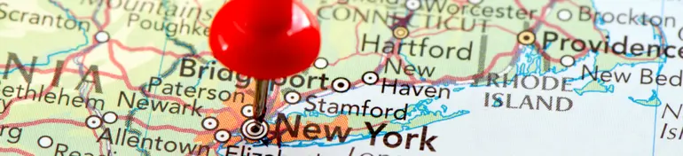 Red push pin marking New York on a map