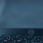 Close-up of a webcam positioned on a laptop keyboard.