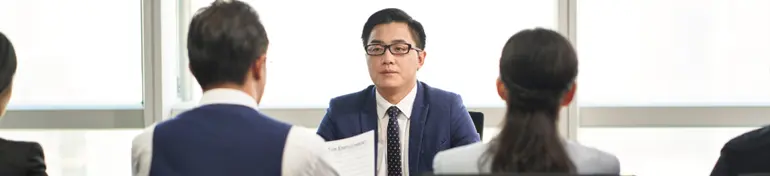 Image of young asian job candidate being interview by a group of hr executives