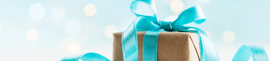 Christmas gift or present box against turquoise background.