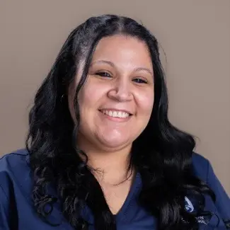 Professional portrait of Customer Service Representative Nicole Moreta wearing blue medical scrubs at Hudson Animal Hospital.