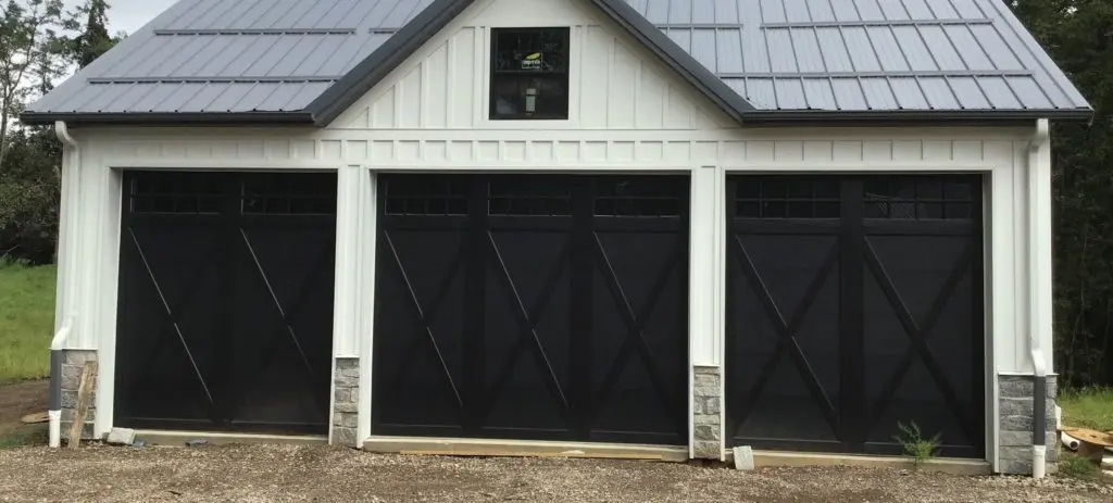 Modern black barn-style garage door with an overlay 