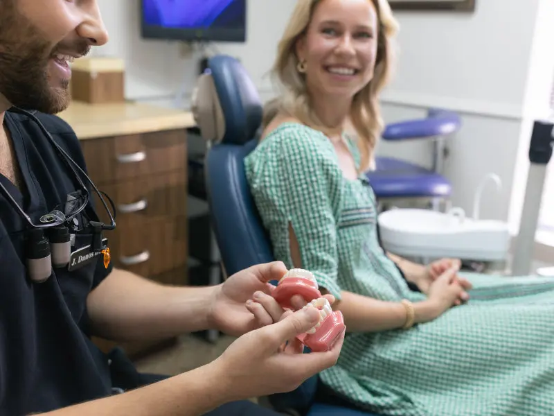Dr. Jaden Danos showing tooth models to patient during consultation at Danos Dental in Murfreesboro, TN