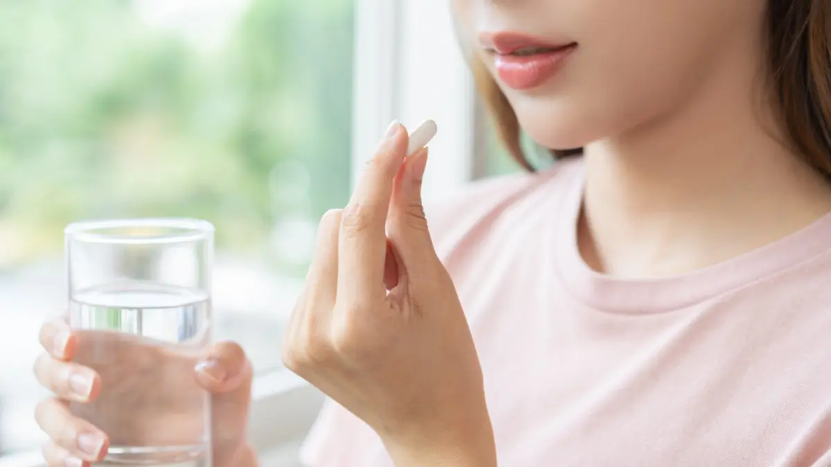 Female patient preparing to take oral sedation pill for dental procedure