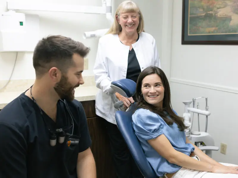 Dr. Jaden Danos talking with female patient while dental hygienist assists at Danos Dental in Murfreesboro, TN