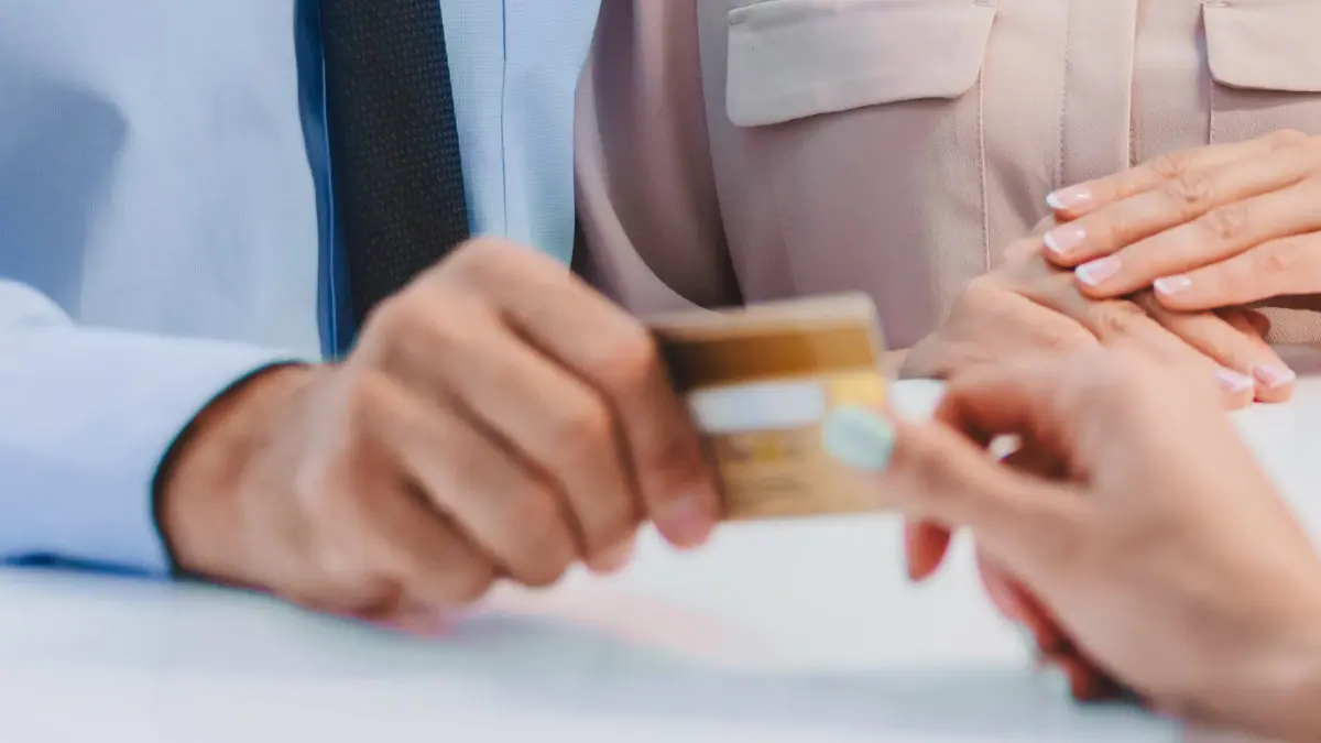 Patient handing credit card for dental payment during checkout