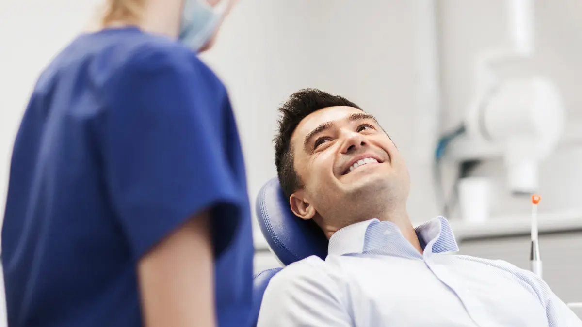 Patient reclined in dental chair for periodontal therapy procedure