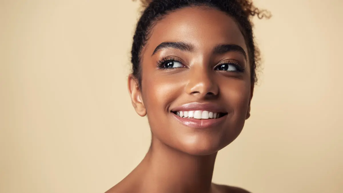 Woman smiling to showcase healthy, bright teeth after cosmetic dentistry