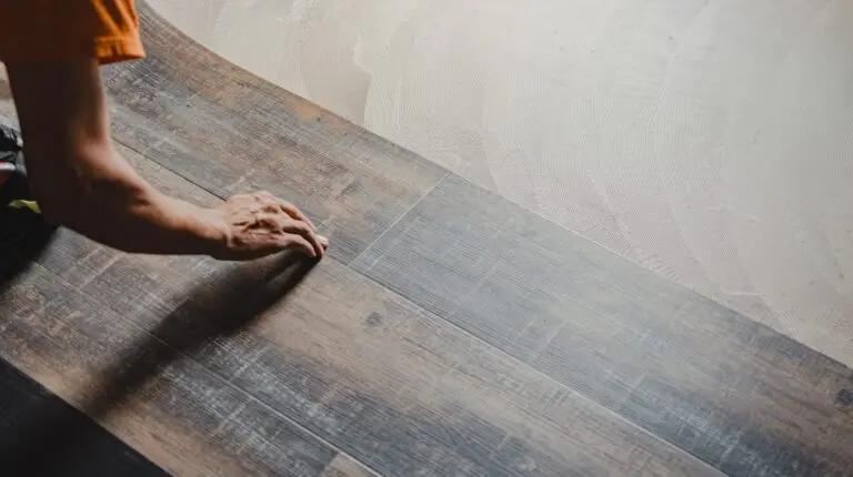 Professional builder laying vinyl tile flooring, using adhesive for perfect installation