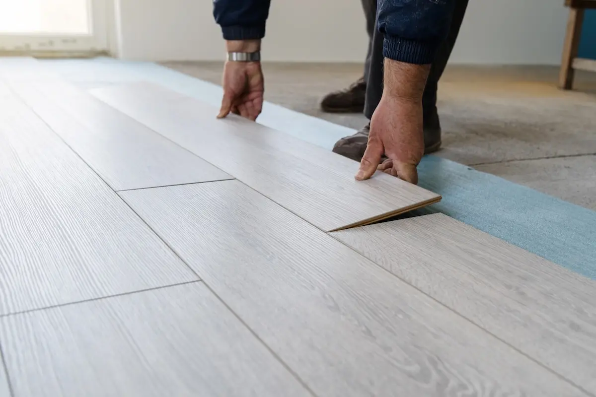 Home renovate with vinyl laminate flooring. Professional construction worker installing new vinyl laminate floor tile