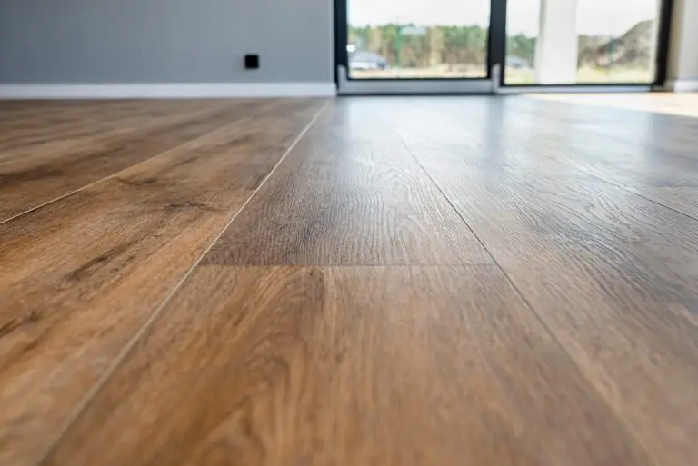 Modern vinyl panels imitating wood in the living room with selective focus and a shadow falling from the window.