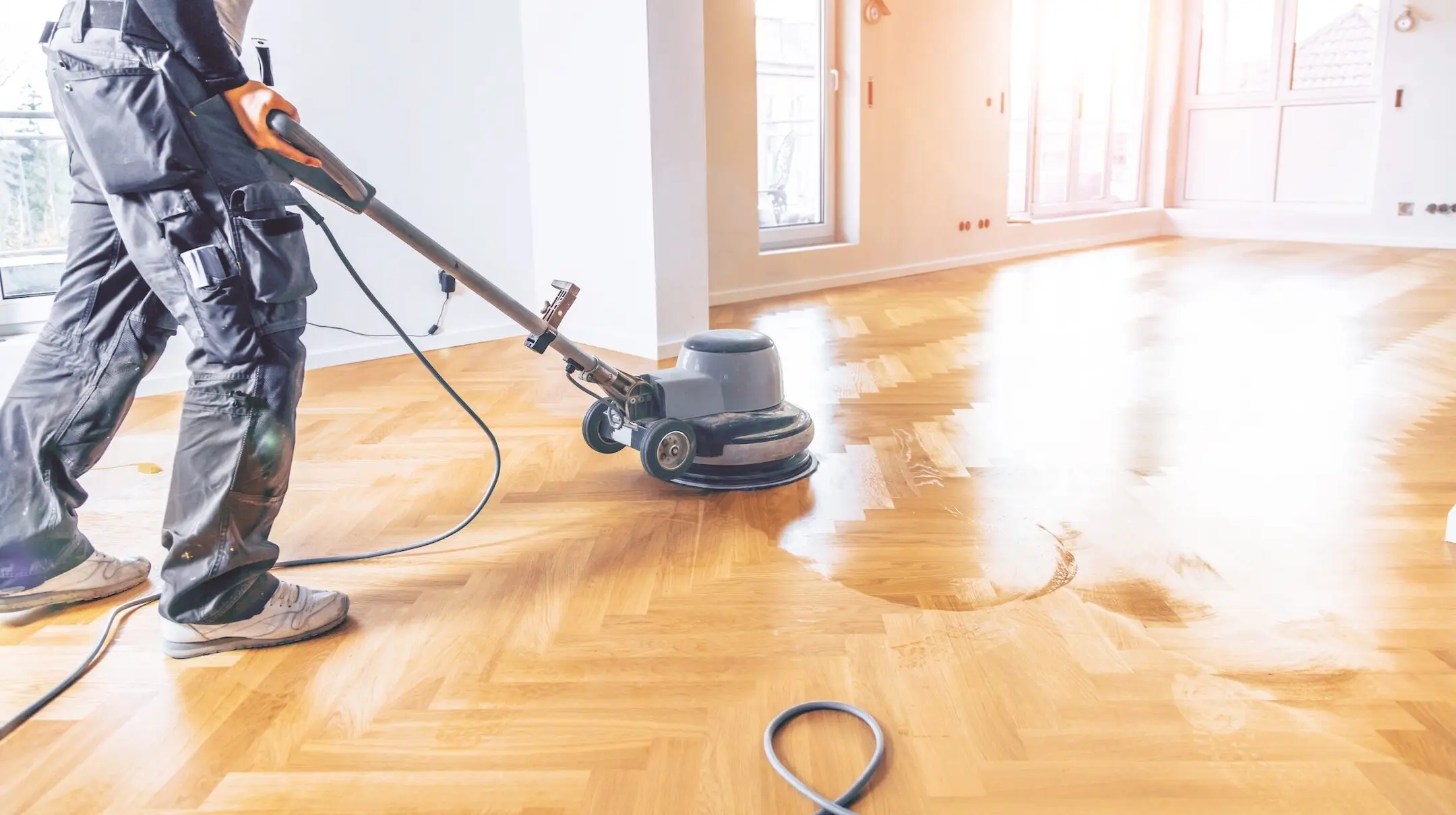 Varnishing of oak parquet floor, workers hand and tool