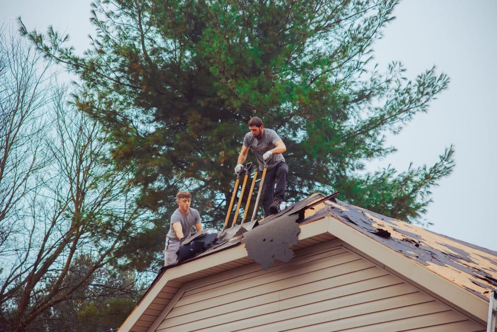 roof replacement cost workers removing old roof