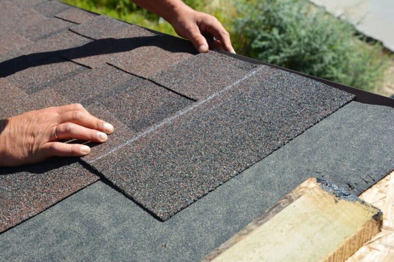 asphalt roof repairs worker installing new shingles