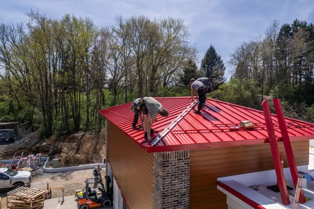 metal roofing options Keim Quality workers repairing red roof