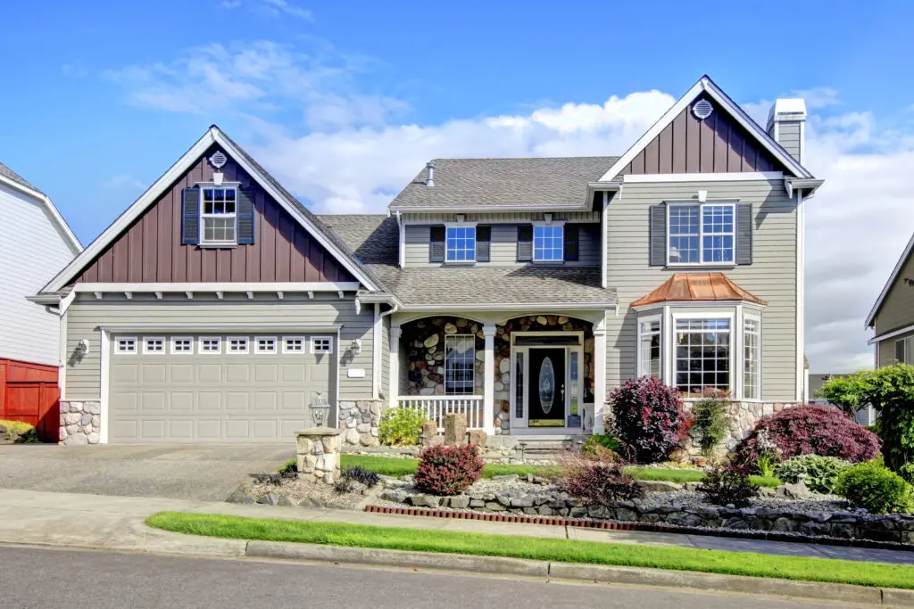 Modern house with navy blue door and perfect decorative front yard.