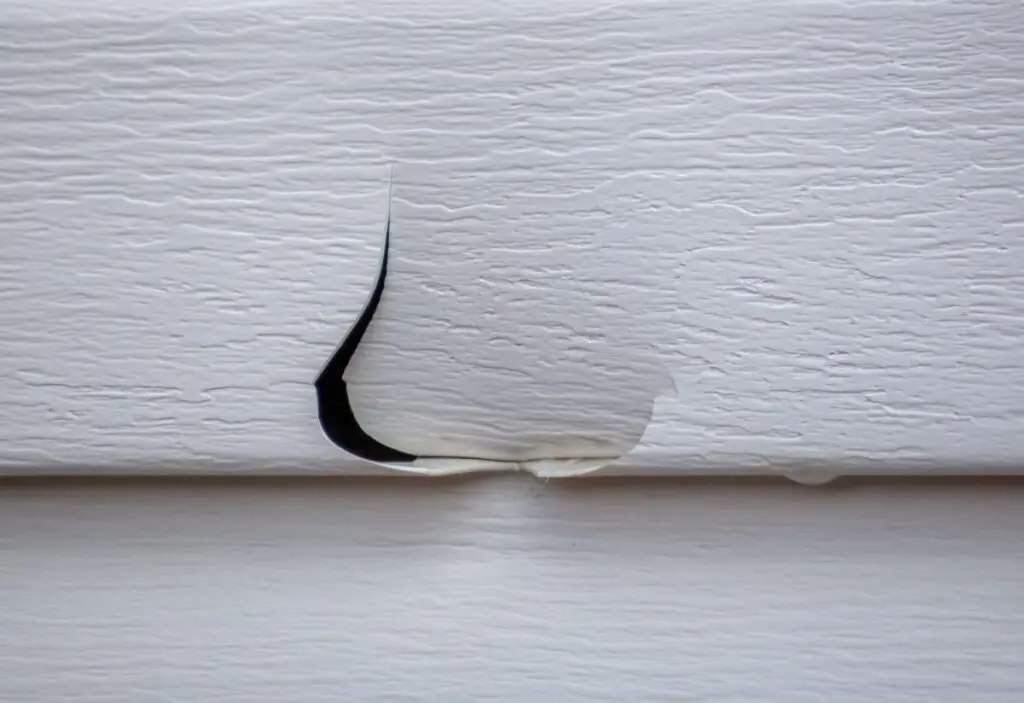 what does hail damage look like on siding closeup white siding cracked