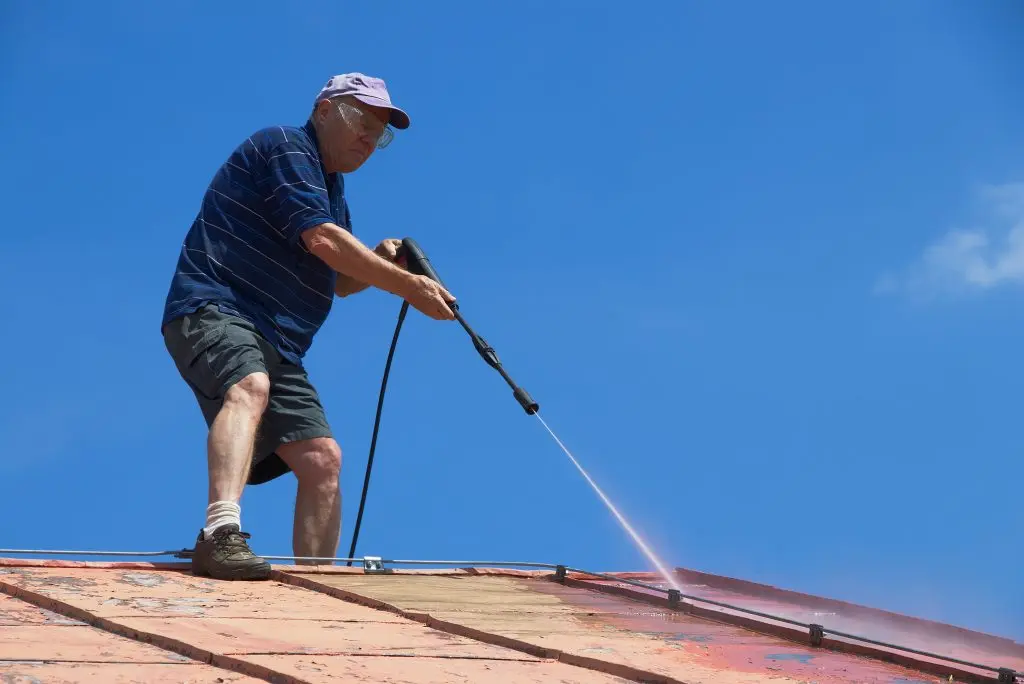 metal roof cleaning old man cleaning roof