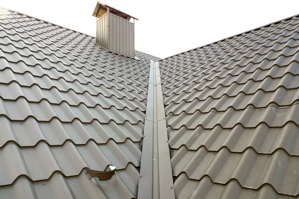 Close up of new house roof structure covered with metal tile sheets.