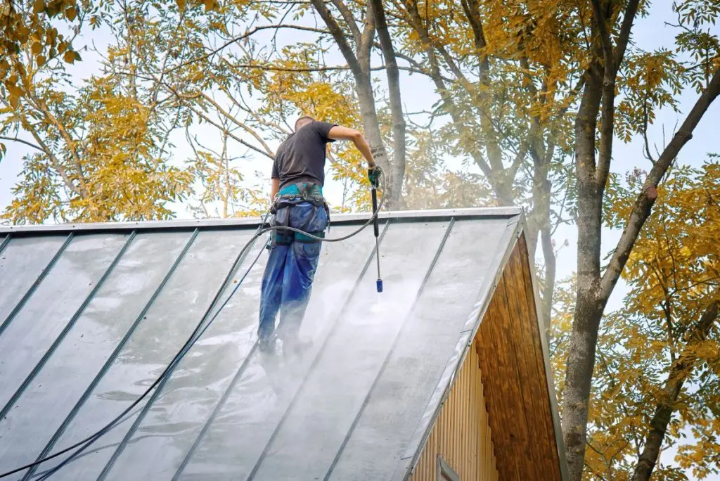 metal roof cleaning guy using pressure to clean roof